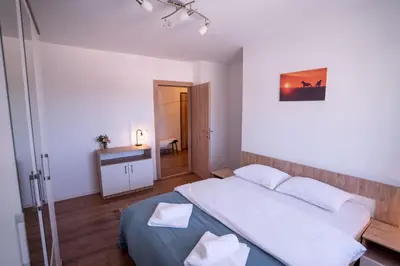 a bedroom with a large bed and a bathroom at Apartman Niko in Livno