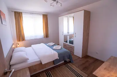 a bedroom with a bed and a large window at Apartman Niko in Livno