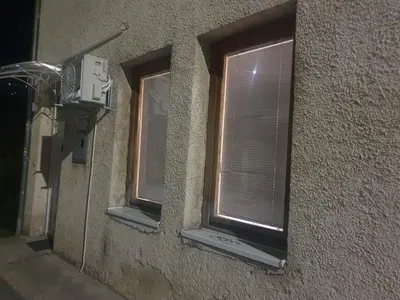 two windows with blinds on a building at OLD HOUSE in Jajce