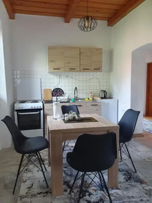 a kitchen with a wooden table and chairs in it at OLD HOUSE in Jajce