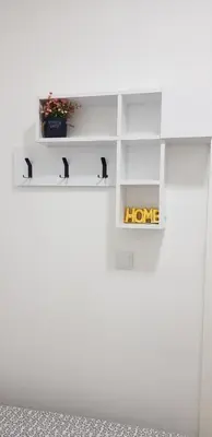 a white shelf with a home sign on a wall at Apartman 555 in Travnik