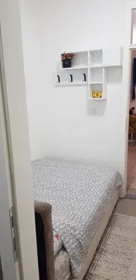 a bedroom with a bed in a white room at Apartman 555 in Travnik