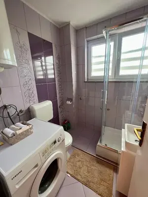 a pink bathroom with a washing machine in it at Apartman Krasota in Banja Luka
