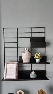 a black shelf with two vases and a book at Apartman Silver in Bugojno