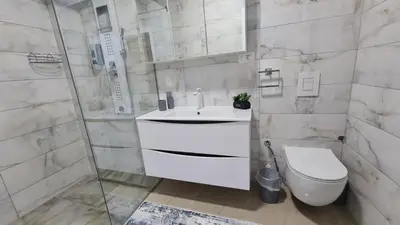 a bathroom with a white sink and a toilet at Apartman Silver in Bugojno