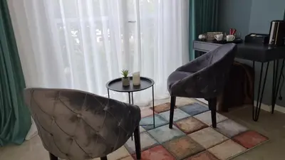 a living room with two chairs and a table at Apartman Silver in Bugojno