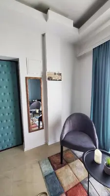 a living room with a chair and a mirror at Apartman Silver in Bugojno