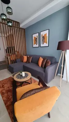 a living room with a blue couch and a table at Apartman Orange in Bugojno