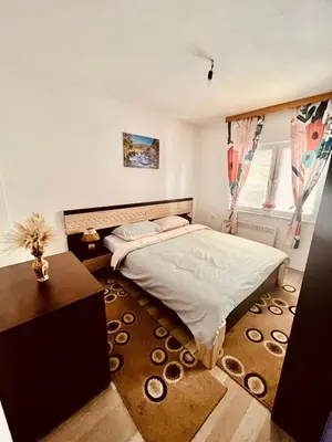 a bedroom with a bed and a table and a window at Summer house LejHana in Bihać