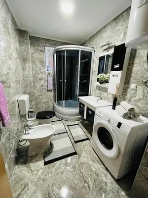 a bathroom with a sink and a washing machine at Summer house LejHana in Bihać