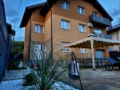 a house with an umbrella and a patio at Summer house LejHana in Bihać