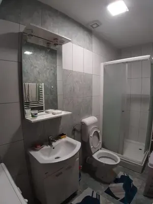 a bathroom with a toilet and a sink and a shower at Stan na dan Modriča in Modriča