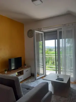 a living room with a couch and a table and a tv at Stan na dan Modriča in Modriča