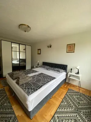 a bedroom with a large bed and a table at Capital Apartments Visoko in Visoko