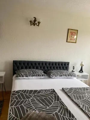 a bedroom with a large bed with a black headboard at Capital Apartments Visoko in Visoko