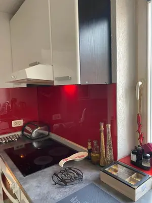 a kitchen with a stove and a red wall at Capital Apartments Visoko in Visoko