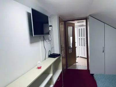 a room with a tv on a wall next to a door at Apartmani Kotor Varoš in Donja Varoš