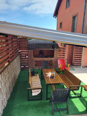 a patio with a table and chairs and a fireplace at Villa Harmony in Bihać