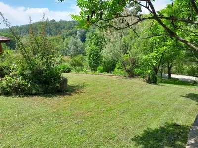 a yard with a field of grass and trees at Vikendica Volar in Prijedor