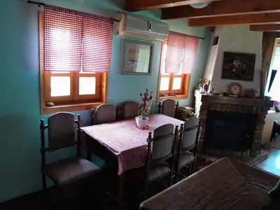 a dining room with a table and chairs and a fireplace at Vikendica Volar in Prijedor