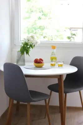 a white table with two chairs and a bowl of fruit at Blue Apartment in Bihać