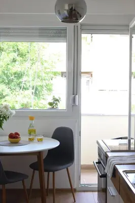 a kitchen with a table and chairs and a window at Blue Apartment in Bihać