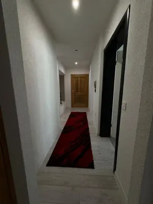 a hallway with a red carpet and a door at Apartman Kumalic in Sanski most