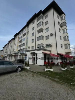 a large building with a car parked in front of it at Apartman Kumalic in Sanski most