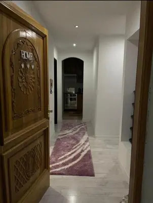 a hallway with a wooden door and a kitchen at Apartman Kumalic in Sanski most