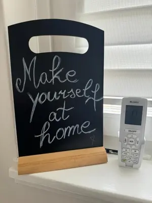 a sign that says make yourself at home next to a phone at Park Apartment in Visoko