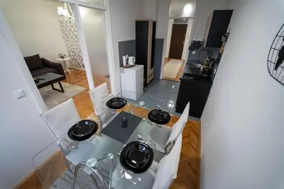 a living room with a glass table and chairs at Park Apartment in Visoko