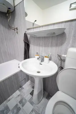 a bathroom with a white sink and a toilet at Park Apartment in Visoko
