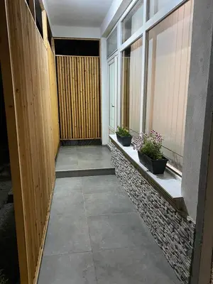 a hallway of a building with windows and plants at Apartman UNA-Plandište in Bihać
