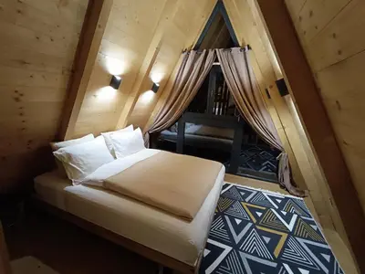a bedroom with a bed in a wooden cabin at Stone Chalets - LUNA in Jajce