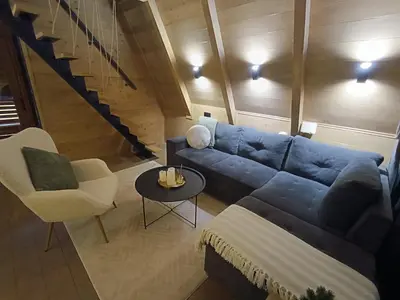 a living room with a blue couch and a table at Stone Chalets - LUNA in Jajce