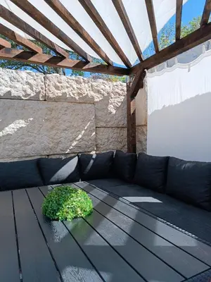 a black couch with a plant on a table at Stone Chalets - LUNA in Jajce