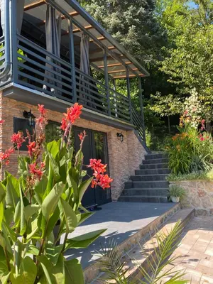 a house with a staircase and red flowers at Vikendica Bella in Bihać