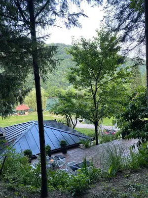 a blue roof in a garden with trees at Vikendica Bella in Bihać