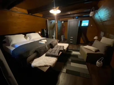 a bedroom with a large bed and a couch at Vikendica Bella in Bihać