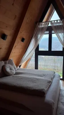 a bed in a room with a large window at Stone Chalets - TERRA in Jajce