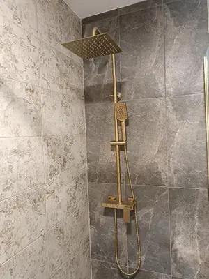a shower with a shower head in a bathroom at Stone Chalets - TERRA in Jajce