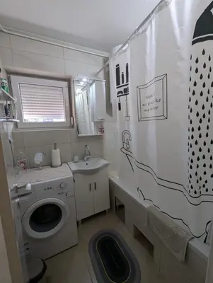 a small bathroom with a washing machine and a sink at Apartment Home Sweet Home in Banja Luka