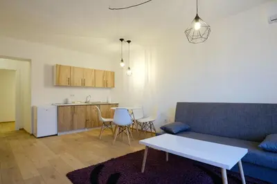 a living room with a couch and a table and a kitchen at Unique Apartments Visoko in Visoko