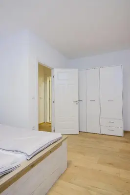 a white bedroom with a bed and white cabinets at Unique Apartments Visoko in Visoko