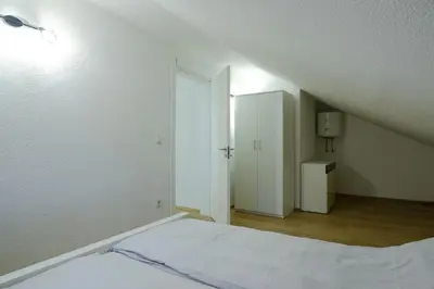 a white room with a bed and a closet at Unique Apartments Visoko in Visoko