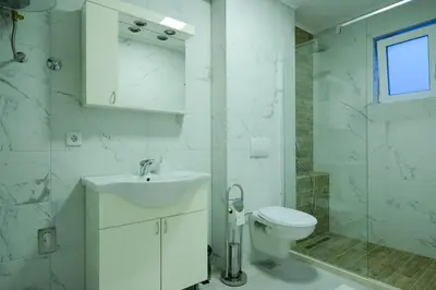 a white bathroom with a sink and a toilet at Unique Apartments Visoko in Visoko