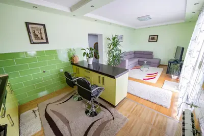 a living room with green walls and a desk and a couch at Spacious apartment (60sqm) with a balcony in Tuzla