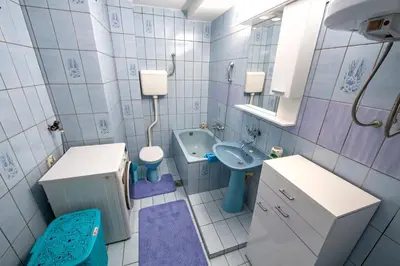 a bathroom with a sink and a toilet and a sink at Spacious apartment (60sqm) with a balcony in Tuzla