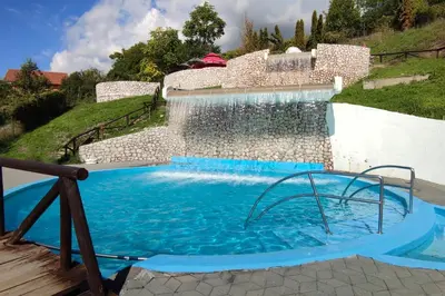 a swimming pool with a waterfall and a water slide at Spacious apartment (60sqm) with a balcony in Tuzla