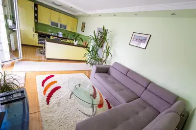 a living room with a purple couch and a rug at Spacious apartment (60sqm) with a balcony in Tuzla